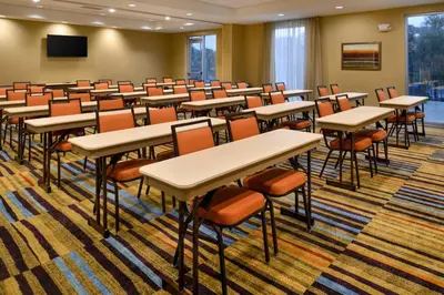 an empty room with desks and chairs in a classroom at Fairfield Inn & Suites by Marriott Orlando East/UCF Area in Orlando