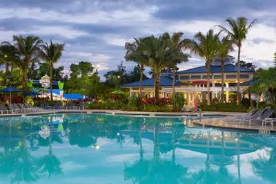 a pool at a resort with palm trees and a building at The Grove Resort & Water Park Orlando in Orlando
