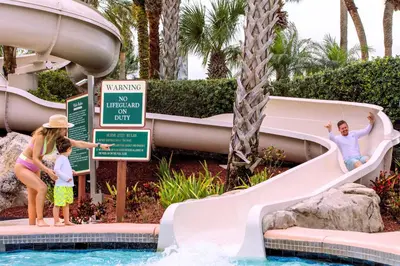 a family playing on a water slide at a resort at Hyatt Regency Grand Cypress Resort - Free Shuttle to Theme Parks! in Orlando