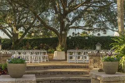 an outdoor wedding with white chairs and tables and trees at Hyatt Regency Grand Cypress Resort - Free Shuttle to Theme Parks! in Orlando