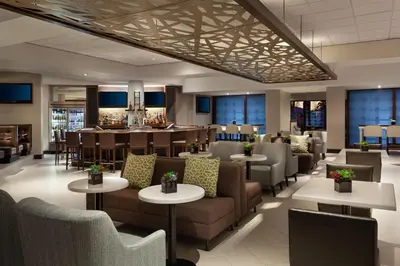 a restaurant with couches and tables and a bar at Marriott Orlando Airport Lakeside in Orlando