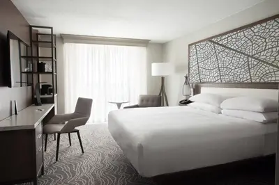 a hotel room with a large white bed and a desk at Marriott Orlando Airport Lakeside in Orlando