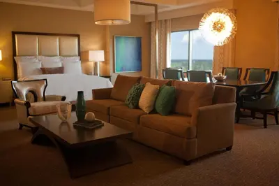 a hotel room with a bed and a couch and a table at Renaissance Orlando at SeaWorld® in Orlando