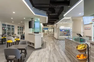 a lobby of a store with tables and chairs at Fairfield Inn & Suites by Marriott Orlando Lake Buena Vista in the Marriott Village in Orlando