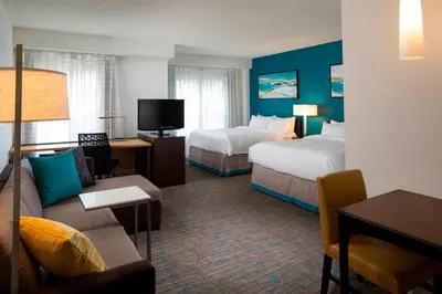 a hotel room with two beds and a couch at Residence Inn by Marriott Orlando at SeaWorld in Orlando