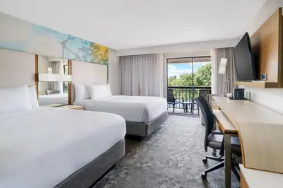 a hotel room with two beds and a desk at Courtyard by Marriott Orlando Lake Buena Vista at Vista Centre in Orlando