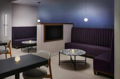 a waiting room with purple furniture and a tv at Courtyard by Marriott Orlando Lake Buena Vista at Vista Centre in Orlando
