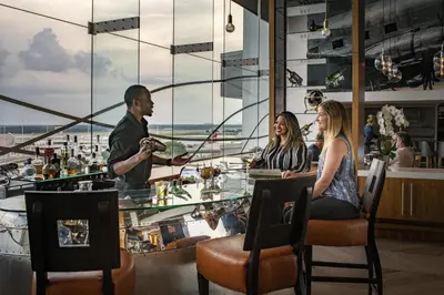 a group of people sitting at a table in a restaurant at Hyatt Regency Orlando International Airport Hotel in Orlando