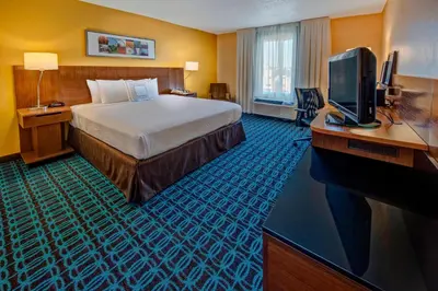 a hotel room with a bed and a flat screen tv at Fairfield Inn and Suites by Marriott Orlando Near Universal Orlando in Orlando