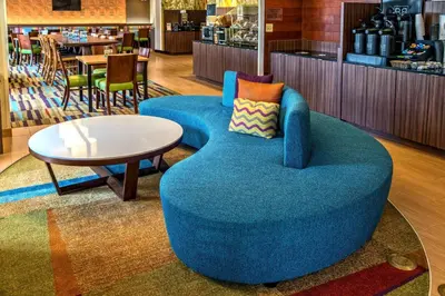 a blue chair and a table in a restaurant at Fairfield Inn and Suites by Marriott Orlando Near Universal Orlando in Orlando