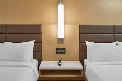 a hotel room with two beds and a table between them at AC Hotel by Marriott Orlando Lake Buena Vista in Orlando