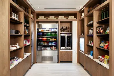 a walk in pantry with wooden shelves and a refrigerator at AC Hotel by Marriott Orlando Lake Buena Vista in Orlando