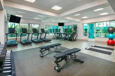a gym with a row of exercise bikes and ellipticals at Hotel Landy Orlando Universal Blvd, a Tribute Portfolio Hotel in Orlando