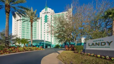 a building with a sign in front of a road at Hotel Landy Orlando Universal Blvd, a Tribute Portfolio Hotel in Orlando
