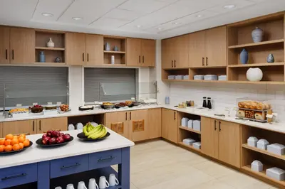 a large kitchen with wooden cabinets and fruits on a counter at Hyatt Place across from Universal Orlando Resort in Orlando