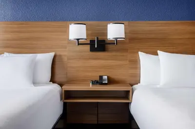 two beds in a hotel room with a nightstand between two beds at Hyatt Place Orlando / I-Drive / Convention Center in Orlando