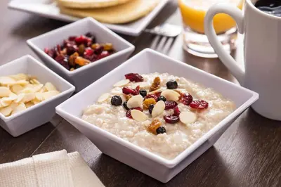 a bowl of oatmeal with fruit and nuts on a table at Hyatt Place Orlando / I-Drive / Convention Center in Orlando