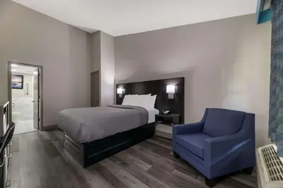 a bedroom with a bed and a blue chair at Quality Inn & Suites Altamonte Springs Orlando-North in Orlando