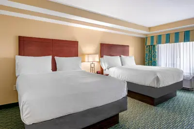 a hotel room with two beds with white sheets at Holiday Inn Resort Orlando - Lake Buena Vista by IHG in Orlando