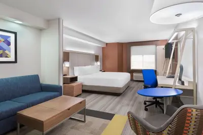 a hotel room with a bed and a couch at Holiday Inn Express & Suites - Nearest Universal Orlando by IHG in Orlando