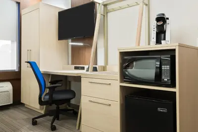 a room with a desk with a microwave and a television at Holiday Inn Express & Suites - Nearest Universal Orlando by IHG in Orlando