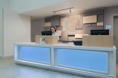 a woman standing behind a counter in an office at Holiday Inn Express & Suites - Nearest Universal Orlando by IHG in Orlando