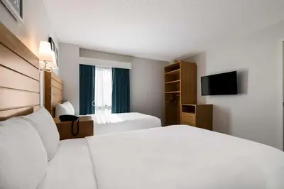 a hotel room with two beds and a television at Sonesta ES Suites Orlando International Drive in Orlando