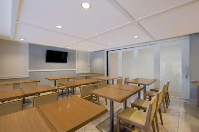 a classroom with wooden tables and chairs and a tv at Sonesta ES Suites Orlando International Drive in Orlando