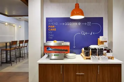 a table with a blue board on the wall at Holiday Inn Express & Suites Orlando International Airport by IHG in Orlando