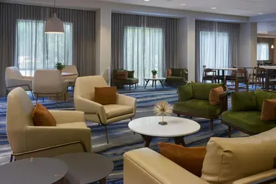 a waiting room with couches and tables and chairs at Fairfield Inn & Suites by Marriott Orlando International Drive/Convention Center in Orlando
