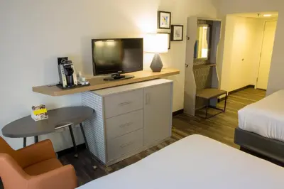 a hotel room with a bed and a tv on a dresser at Holiday Inn Orlando International Airport by IHG in Orlando