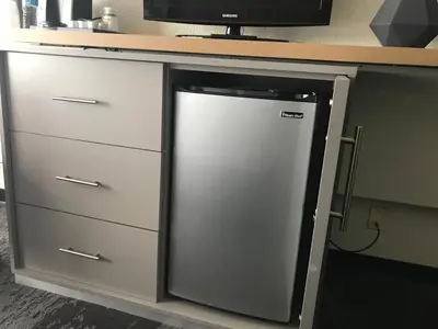 a refrigerator under a counter in a kitchen at Holiday Inn Orlando International Airport by IHG in Orlando