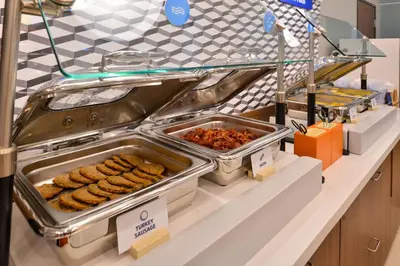 a buffet line with trays of food on a counter at Holiday Inn Express Orlando-Ocoee East by IHG in Orlando