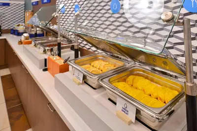 a buffet line with trays of food on display at Holiday Inn Express Orlando-Ocoee East by IHG in Orlando