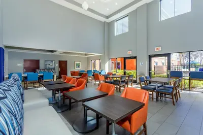 a dining room with tables and chairs and windows at Holiday Inn Express Orlando-Ocoee East by IHG in Orlando