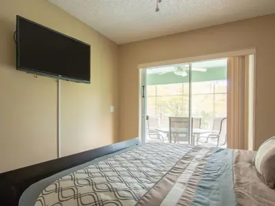 a bedroom with a bed and a flat screen tv at 3 Bed 258 in Kissimmee