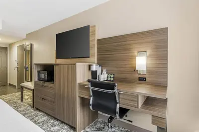 a hotel room with a desk with a television and a chair at Best Western Plus Sanford Airport/Lake Mary Hotel in Sanford