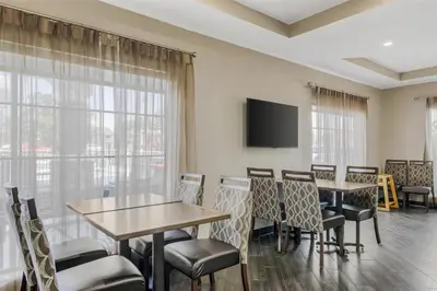 a conference room with tables and chairs and a flat screen tv at Best Western Plus Sanford Airport/Lake Mary Hotel in Sanford