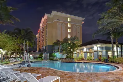 a hotel with a pool in front of a building at Homewood Suites by Hilton Lake Buena Vista Orlando - Newly Renovated! in Orlando