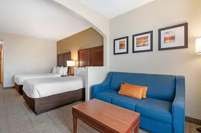 a hotel room with a bed and a blue couch at Comfort Suites Downtown in Orlando