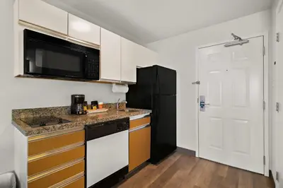 a kitchen with white cabinets and a black refrigerator at MainStay Suites Orlando Altamonte Springs in Orlando