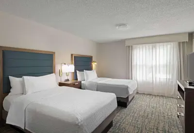 a hotel room with two beds and a television at Homewood Suites by Hilton Lake Mary Orlando North in Lake Mary
