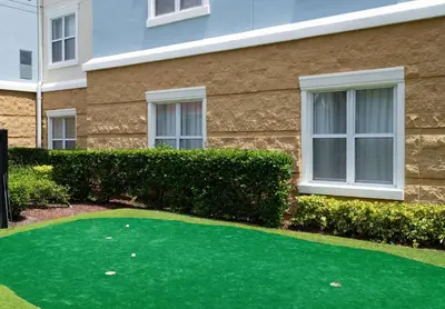 a building with a green putting green in front of a building at Homewood Suites by Hilton Lake Mary Orlando North in Lake Mary