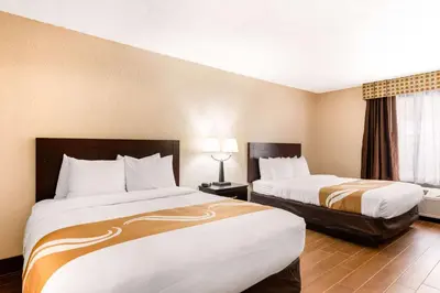 a hotel room with two beds and a window at Quality Inn & Suites Orlando Airport in Orlando