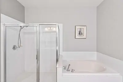 a white bathroom with a shower and a tub at Hidden Treasure in Orlando