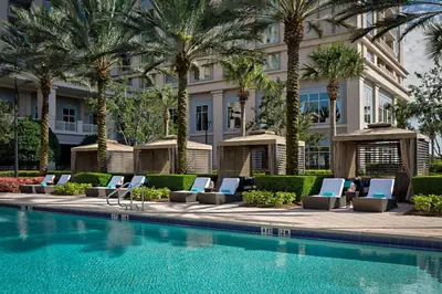 a hotel swimming pool with lounge chairs and palm trees at Waldorf Astoria Orlando - An Official Walt Disney World Hotel in Orlando