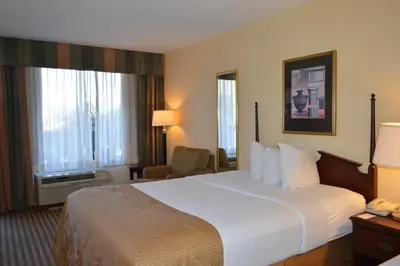 a hotel room with a large bed and a chair at Opal Hotel & Suites in Orlando