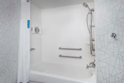 a bathroom with a shower and a white tub at Hampton Inn & Suites at Lake Mary Colonial Townpark in Lake Mary