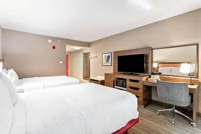 a hotel room with two beds and a desk with a television at Hampton Inn & Suites Orlando-Apopka in Orlando