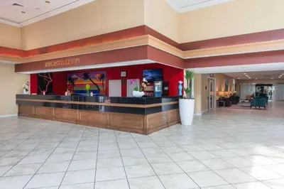 a lobby with a bar in a hotel at Ramada by Wyndham Kissimmee Gateway - Free Theme Park Shuttle in Orlando